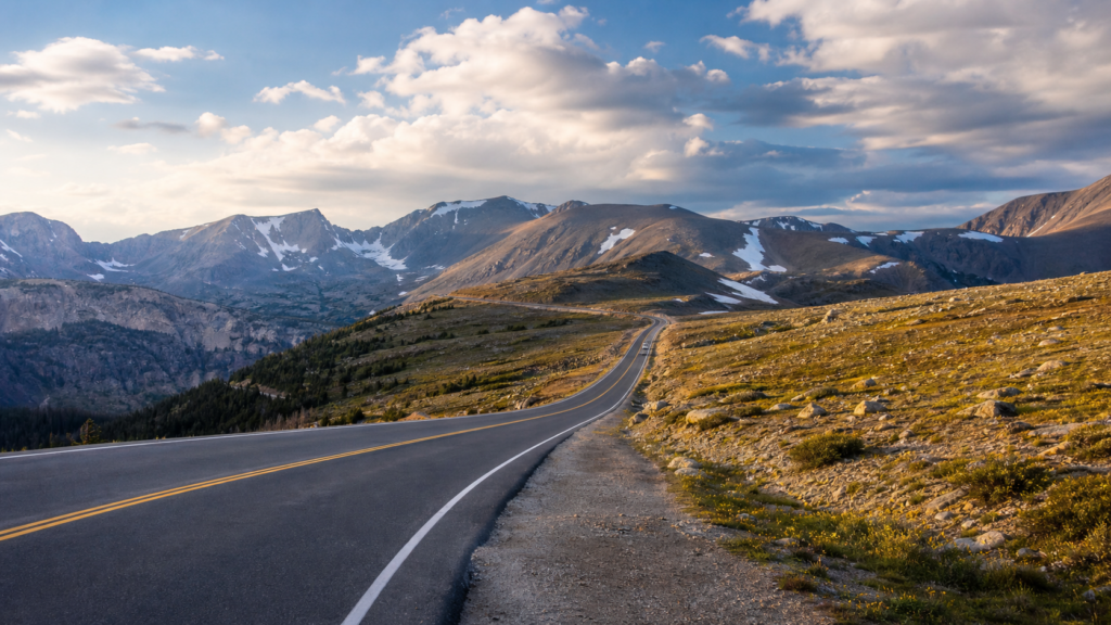 A motorhome driving through Rocky Mountain National Park scenery for an RV trip planner